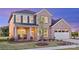 Charming two-story brick home with a manicured lawn and inviting front porch with rocking chairs at 13943 Penbury Ln # 376, Charlotte, NC 28278
