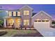 Charming two-story brick home with a manicured lawn and inviting front porch with rocking chairs at 13943 Penbury Ln # 376, Charlotte, NC 28278