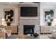 Comfortable living room features a stylish brick fireplace, a large flatscreen TV and neutral toned decor at 13943 Penbury Ln # 376, Charlotte, NC 28278