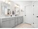 Bathroom with marble floors, double vanity with framed mirrors, gold hardware, and white cabinets at 15124 Hugh Mcauley Rd, Huntersville, NC 28078