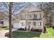 Charming two-story home with a covered front porch and well-maintained lawn and an attached garage at 15124 Hugh Mcauley Rd, Huntersville, NC 28078