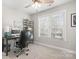 Well-lit home office with a modern desk, comfortable chair, and a large window view at 15124 Hugh Mcauley Rd, Huntersville, NC 28078