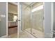 Bright bathroom featuring a glass-enclosed shower, neutral tile and gray paint at 15311 Lake Ridge Rd, Charlotte, NC 28278