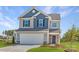 Charming two-story home with a two-car garage, manicured lawn, and colorful flower beds at 15311 Lake Ridge Rd, Charlotte, NC 28278