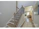 Staircase with decorative wrought iron railing transitioning to open-concept living space at 15311 Lake Ridge Rd, Charlotte, NC 28278