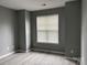 Comfortable bedroom features laminate flooring, fresh gray paint, and natural lighting at 1634 Walnut View Dr, Charlotte, NC 28208