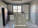 Modern kitchen featuring white cabinets, stainless refrigerator, and granite countertop island at 1634 Walnut View Dr, Charlotte, NC 28208