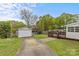 Spacious backyard featuring mature trees, a garage, a patio, and lush greenery at 1644 Morningside Dr, Charlotte, NC 28205