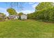 Green backyard with lush lawn, well-kept garden beds, and mature greenery creating a tranquil outdoor environment at 1644 Morningside Dr, Charlotte, NC 28205