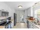 White kitchen features stainless steel appliances, granite countertops, and tile flooring at 1644 Morningside Dr, Charlotte, NC 28205