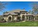 Stunning home featuring a manicured lawn, stone accents, arched entryway, and meticulously maintained landscaping at 16744 Ashton Oaks Dr, Charlotte, NC 28278