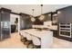 Modern kitchen featuring stainless appliances, an oversized island, and unique light fixtures at 16744 Ashton Oaks Dr, Charlotte, NC 28278