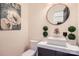 Stylish powder room featuring a square sink, a round mirror, and decorative accents at 16744 Ashton Oaks Dr, Charlotte, NC 28278