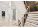 Bright, open staircase features wooden steps, black metal railings, and a glass-enclosed wine storage area at 16744 Ashton Oaks Dr, Charlotte, NC 28278