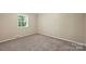 Neutral bedroom featuring a cozy carpet, window with blinds, and a simple, functional design at 1837 Academy St, Charlotte, NC 28205