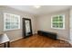 Bedroom with hardwood floors, two windows letting in natural light, and a dark wood media console at 1837 Academy St, Charlotte, NC 28205