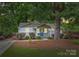 Charming single-story home featuring a blue front door, landscaped yard, and mature trees at 1837 Academy St, Charlotte, NC 28205