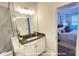 A bathroom featuring a marble shower, vanity with white cabinets, and a view into the main bedroom at 19732-A School St, Cornelius, NC 28031