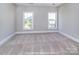 Bedroom with neutral carpet, two bright windows, and neutral gray walls with white trim at 19732-A School St, Cornelius, NC 28031
