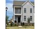 Charming two-story townhome with gray siding, black window frames, a covered porch, and a brick foundation at 19732-A School St, Cornelius, NC 28031