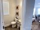 A compact half bathroom with modern fixtures, stylish decor, and wood-look flooring, located off the living area at 19732-A School St, Cornelius, NC 28031