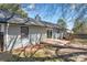 Backyard view of home exterior, a small deck, and partially shaded lawn at 205 King David Ln, Gastonia, NC 28056