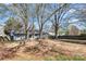 Large backyard with mature trees providing ample shade, and fenced perimeter at 205 King David Ln, Gastonia, NC 28056