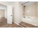 Bright bathroom featuring a soaking tub with tile surround and modern fixtures at 205 King David Ln, Gastonia, NC 28056