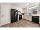 Spacious kitchen featuring white cabinetry, black appliances, modern backsplash, and wood-look flooring at 205 King David Ln, Gastonia, NC 28056