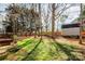 Landscaped backyard with a shed, mature trees, and a wooden fence, offering a serene and private outdoor retreat at 2426 Tory Oak Pl, Matthews, NC 28105