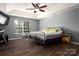 Spacious bedroom with a tray ceiling, ceiling fan, and hardwood floors at 2426 Tory Oak Pl, Matthews, NC 28105