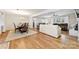 Open-concept living space showcases hardwood floors, a brick fireplace, and seamless flow between dining and living areas at 2540 Deal Rd, Mooresville, NC 28115