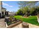 Large backyard features a firepit, raised garden beds, playset, and a lush green lawn and patio space at 300 Mammoth Oaks Dr, Charlotte, NC 28270