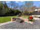 Backyard featuring a stone fire pit with built-in seating, a playset, a grill, and lush green grass at 300 Mammoth Oaks Dr, Charlotte, NC 28270