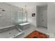 Primary bathroom featuring a soaking tub, walk-in glass shower and marble tile at 300 Mammoth Oaks Dr, Charlotte, NC 28270