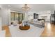 Bright open-concept living space with hardwood floors, access to the patio and view to the kitchen at 300 Mammoth Oaks Dr, Charlotte, NC 28270