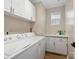Laundry room with white washer, dryer, cabinets and tile backsplash at 3140 S Legacy Park Blvd, Fort Mill, SC 29707