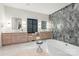 Bathroom with dual vanities, marble countertop, walk-in shower, and freestanding tub at 401 Woodland St, Davidson, NC 28036
