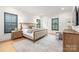 Bright bedroom featuring wood floors, a beige bed frame, and black window shutters at 401 Woodland St, Davidson, NC 28036