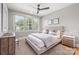 This bedroom features a ceiling fan, large window for natural light, neutral tones, and modern decor at 401 Woodland St, Davidson, NC 28036