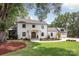 Beautifully landscaped two-story home with classic architecture, mature trees and a circular driveway at 401 Woodland St, Davidson, NC 28036