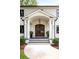 The front entrance of this home features a covered porch with an arched entryway and wood double doors at 401 Woodland St, Davidson, NC 28036