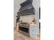 Gourmet kitchen featuring a high-end range, custom hood, and view to the dining area at 401 Woodland St, Davidson, NC 28036