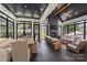 Inviting sunroom with vaulted ceilings, a fireplace, and large windows offering tranquil views of the surrounding landscape at 401 Woodland St, Davidson, NC 28036