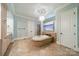 Bright bathroom featuring a standalone tub, tiled floor, and stylish chandelier at 492 Agnew Rd, Mooresville, NC 28117