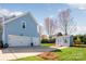 Exterior of the home with a two-car garage, lovely landscaping, and an adorable shed at 5601 Underwood Ave, Charlotte, NC 28213