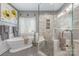 Elegant bathroom featuring a soaking tub and glass shower with decorative tile and modern fixtures at 5601 Underwood Ave, Charlotte, NC 28213