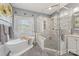 Elegant bathroom featuring a soaking tub and glass shower with decorative tile and modern fixtures at 5601 Underwood Ave, Charlotte, NC 28213