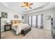 Bedroom with tray ceilings, a king bed, a leather trunk and a ceiling fan at 5601 Underwood Ave, Charlotte, NC 28213