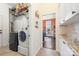 Functional laundry room with modern washer and dryer, storage shelves, and access to other living spaces at 5601 Underwood Ave, Charlotte, NC 28213
